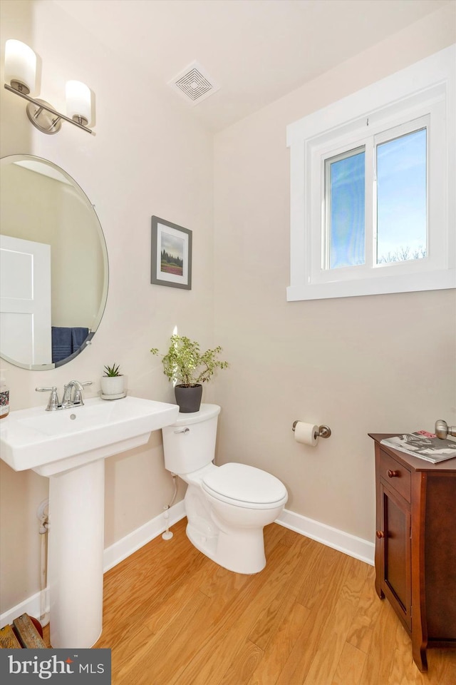 bathroom with hardwood / wood-style floors and toilet