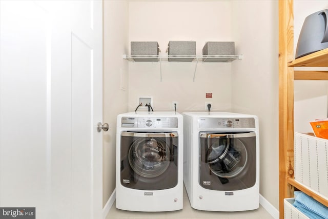 laundry area featuring washer and clothes dryer and light tile patterned floors