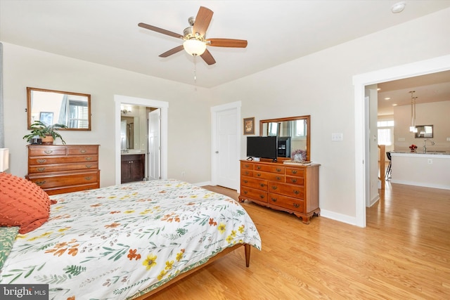 bedroom featuring multiple windows, ceiling fan, sink, and light wood-type flooring