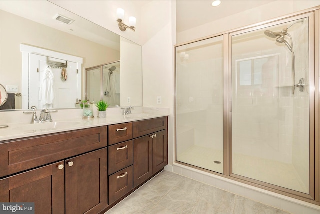 bathroom featuring tile patterned flooring, vanity, and a shower with shower door