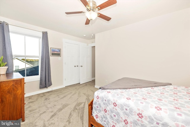 bedroom with light carpet, a closet, and ceiling fan