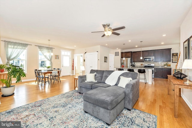 living room with light hardwood / wood-style floors and ceiling fan