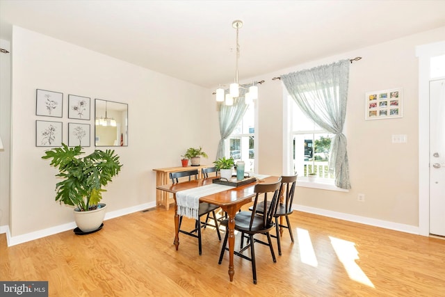 dining room with a notable chandelier and light wood-type flooring