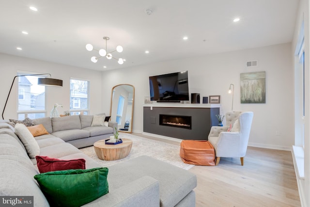 living room with a chandelier and light wood-type flooring