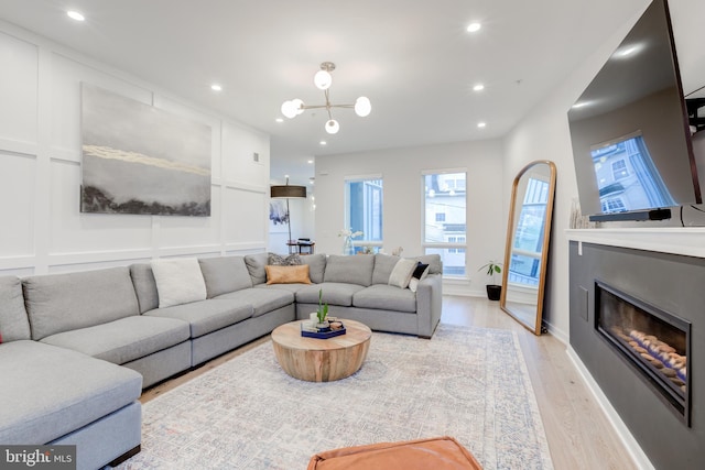 living room featuring light hardwood / wood-style floors and an inviting chandelier