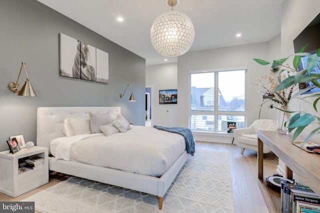 bedroom featuring light wood-type flooring and a notable chandelier