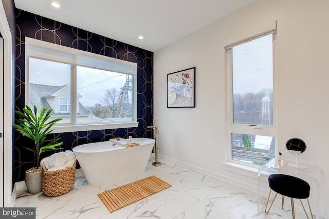 bathroom featuring a tub and a wealth of natural light