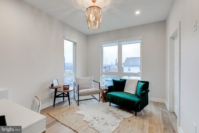 sitting room with light hardwood / wood-style floors and an inviting chandelier