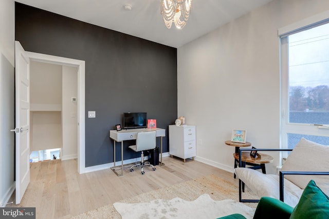 office space featuring light hardwood / wood-style floors and an inviting chandelier