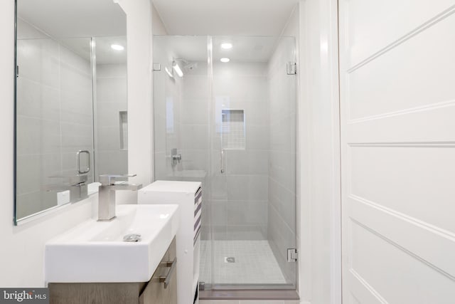 bathroom featuring vanity and a shower with shower door