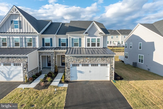 view of front of property with driveway, roof with shingles, an attached garage, a standing seam roof, and board and batten siding