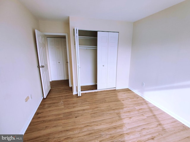 unfurnished bedroom with light hardwood / wood-style floors and a closet