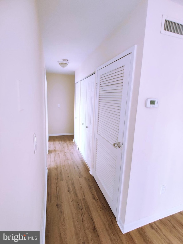 corridor with dark hardwood / wood-style flooring