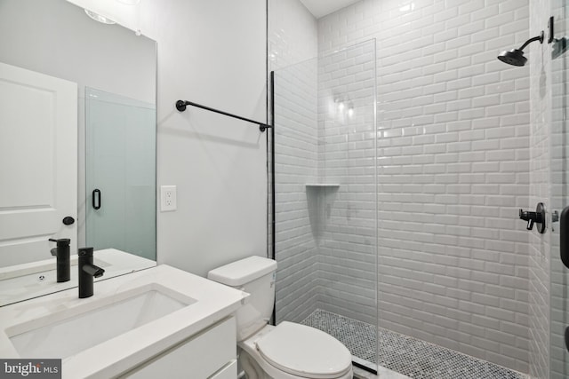 bathroom with vanity, an enclosed shower, and toilet