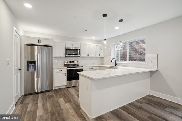 kitchen featuring kitchen peninsula, stainless steel appliances, white cabinetry, and sink