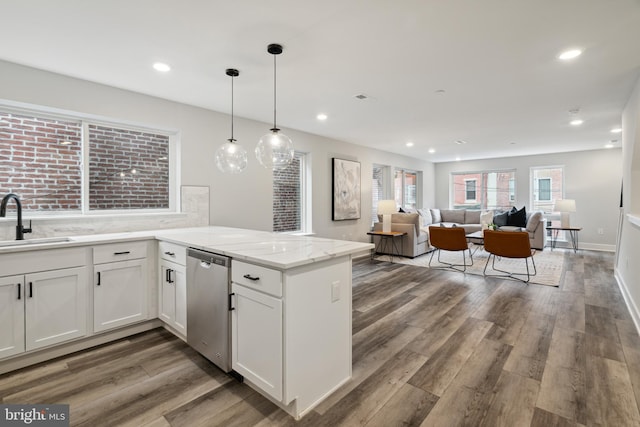 kitchen featuring dishwasher, sink, light stone counters, kitchen peninsula, and white cabinets