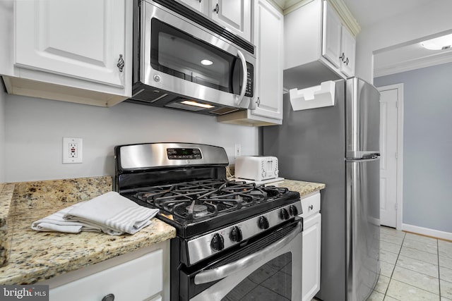 kitchen with light tile patterned floors, stainless steel appliances, white cabinetry, and crown molding