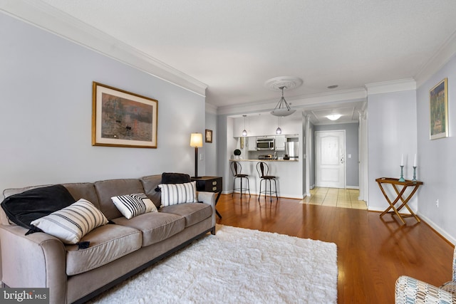 living room with baseboards, light wood-style flooring, and crown molding