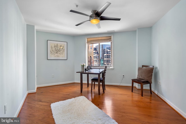 living area with baseboards, visible vents, ceiling fan, and wood finished floors