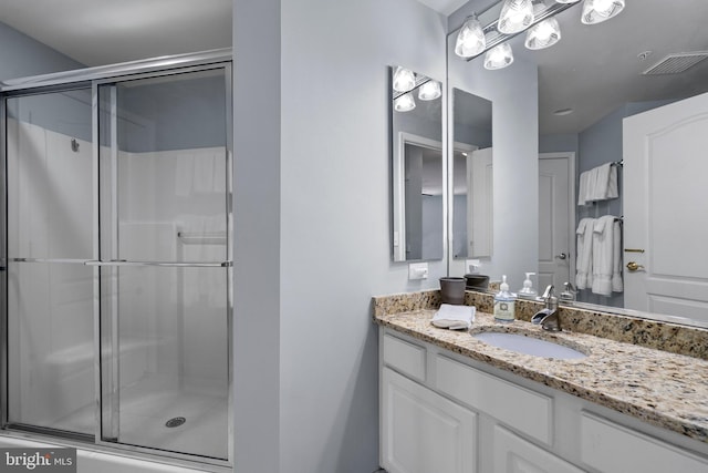 bathroom with a shower stall and vanity