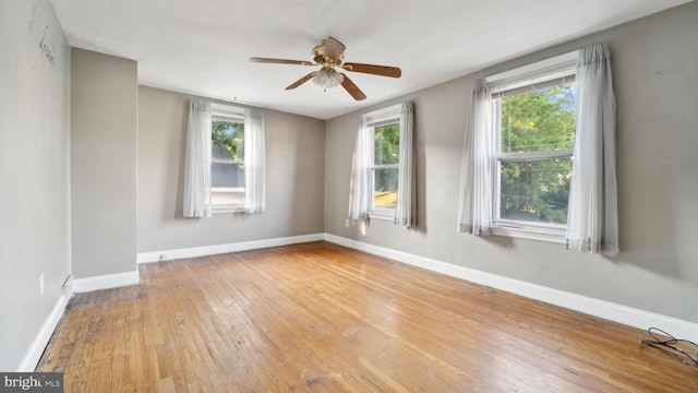 empty room featuring a wealth of natural light, ceiling fan, and light hardwood / wood-style floors