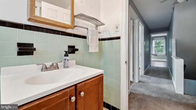 bathroom with vanity, ceiling fan, and tile walls