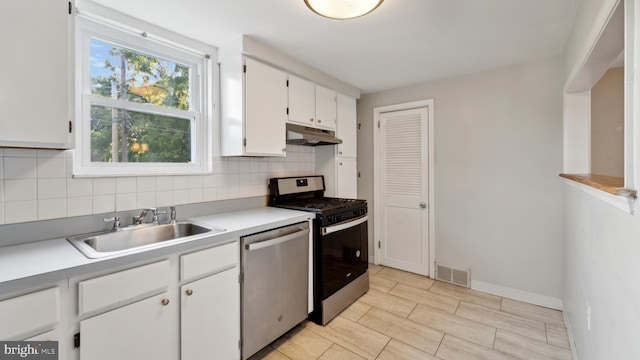 kitchen with tasteful backsplash, stainless steel dishwasher, sink, white cabinets, and range