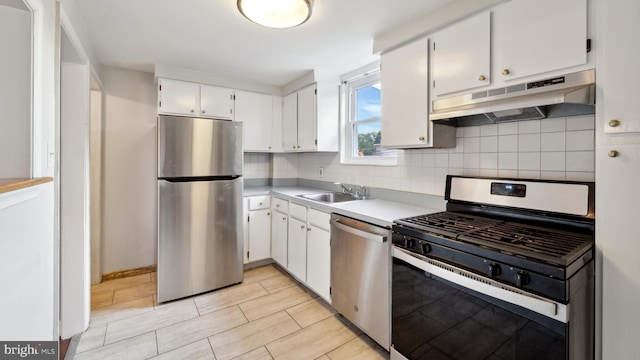 kitchen featuring white cabinets, decorative backsplash, stainless steel appliances, and sink