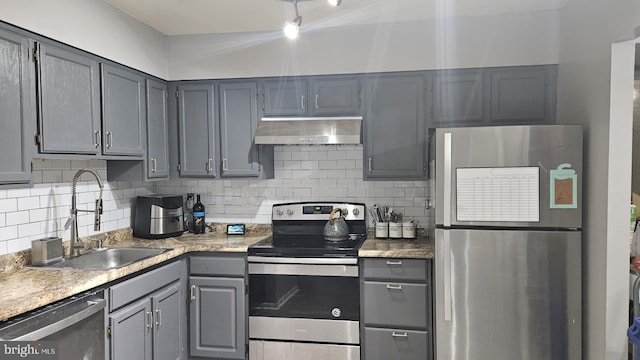 kitchen featuring gray cabinetry, sink, stainless steel appliances, and tasteful backsplash