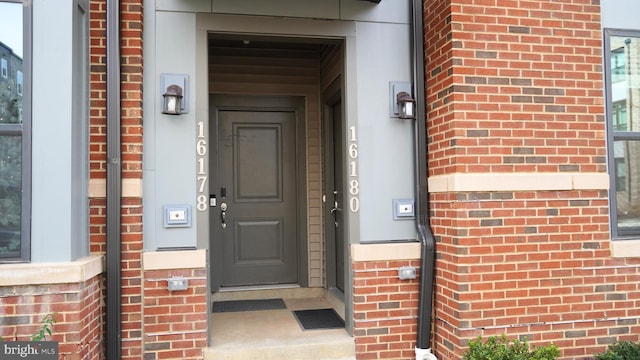 entrance to property featuring brick siding