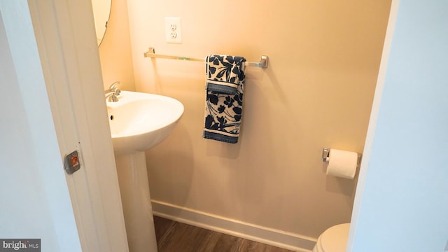 bathroom with hardwood / wood-style floors and toilet