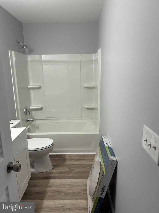 full bathroom featuring vanity, toilet, wood-type flooring, and shower / washtub combination