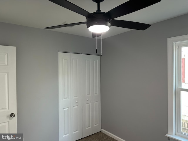 unfurnished bedroom with carpet, a closet, and ceiling fan