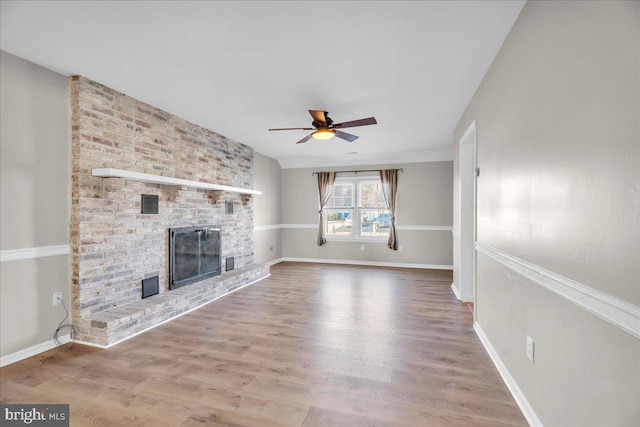 unfurnished living room featuring ceiling fan, a fireplace, and wood-type flooring