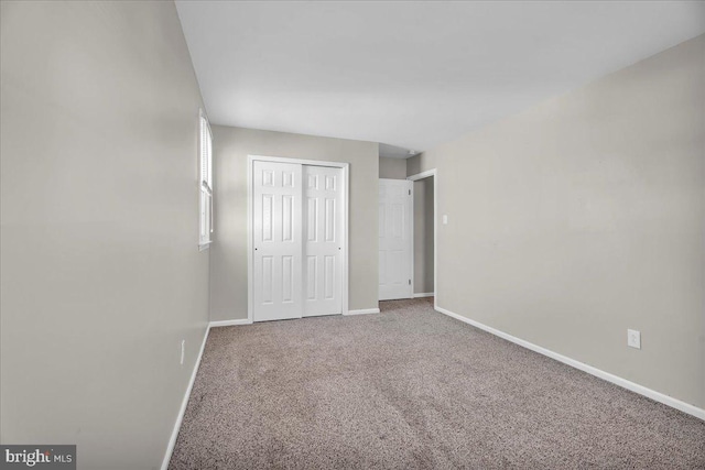 unfurnished bedroom with a closet and carpet