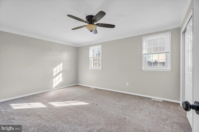 carpeted empty room with ceiling fan and crown molding