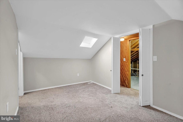 bonus room featuring carpet floors and vaulted ceiling with skylight