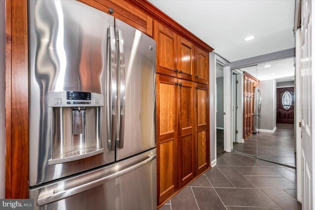 kitchen featuring stainless steel fridge with ice dispenser and dark tile patterned flooring