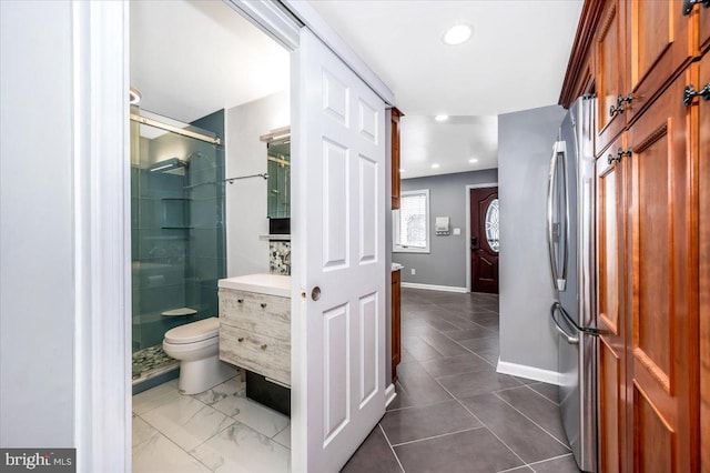 bathroom with vanity, toilet, and a shower with shower door