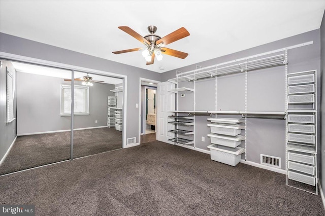 spacious closet with dark colored carpet