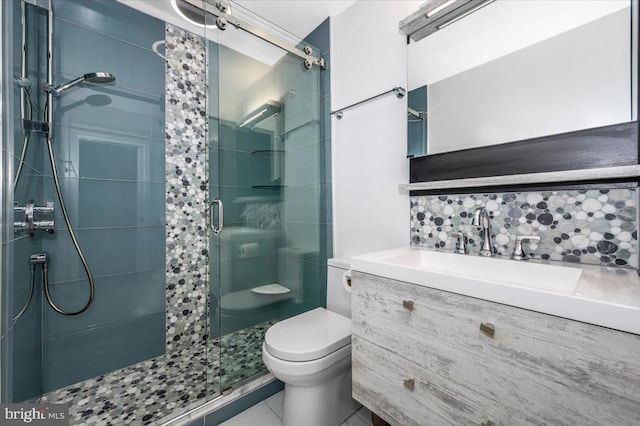 bathroom with tile patterned flooring, vanity, a shower with shower door, and toilet