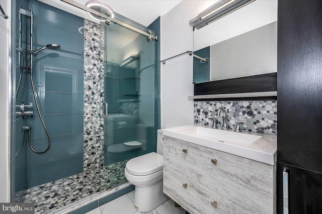 bathroom with backsplash, tile patterned floors, vanity, a shower with door, and toilet