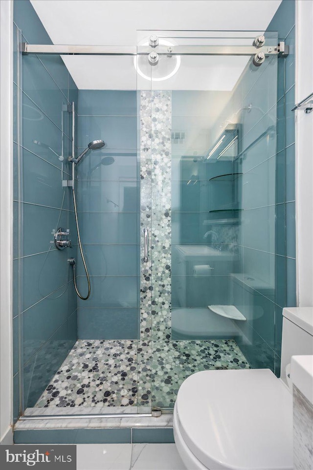 bathroom with tile patterned flooring, toilet, and an enclosed shower