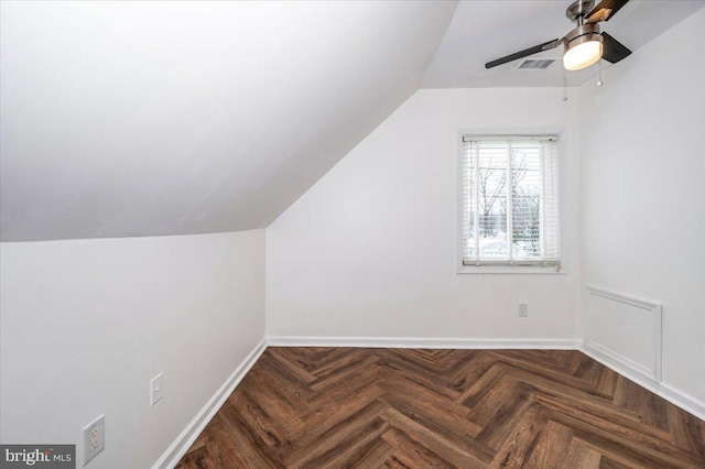 additional living space featuring ceiling fan, dark parquet floors, and lofted ceiling