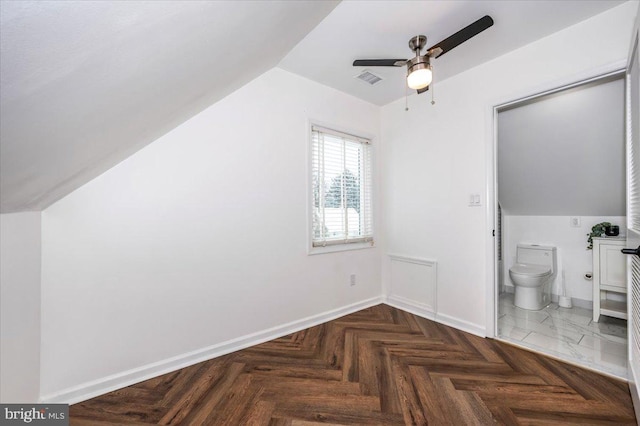 additional living space with dark parquet floors, ceiling fan, and lofted ceiling