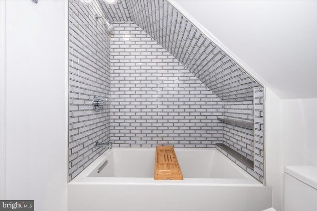 bathroom with a washtub and toilet