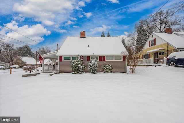 snow covered property with a carport