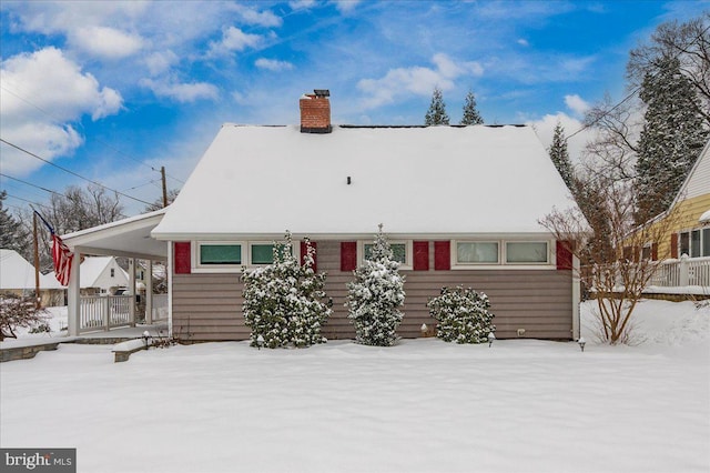 snow covered property with a carport