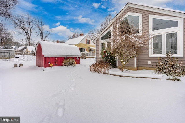 view of snowy exterior featuring a storage unit