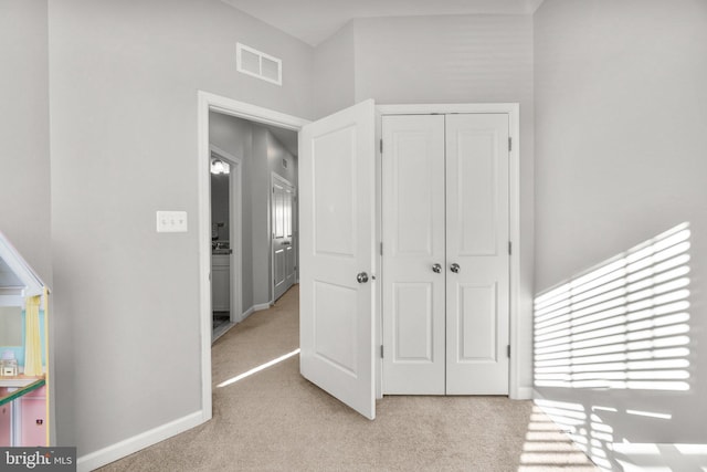 bedroom with light colored carpet and a closet